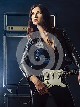 Beautiful woman on stage playing guitar