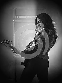 Beautiful woman on stage playing guitar