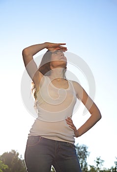 Beautiful woman standing against the sky. Sunny day