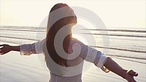 Beautiful woman standing with arms outstretched on shore