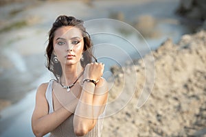 Beautiful woman standing on the beach posing with jewelry