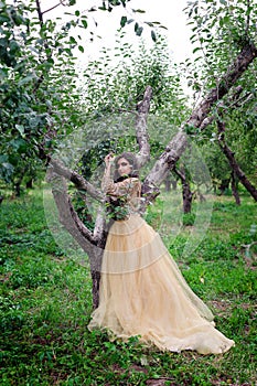 Beautiful woman is standing between the branch of tree