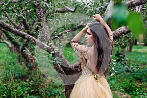 Beautiful woman is standing between the branch of tree
