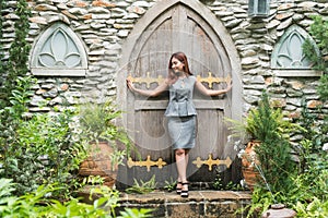 Beautiful woman standing at the door in the garden