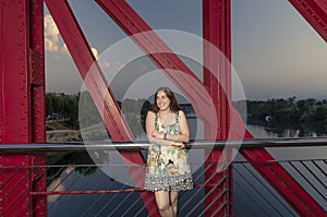 Beautiful woman standing on the red bridge over Ebro, Spain