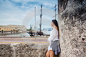 Beautiful woman standing at the walls of Cartagena de Indias looking to the bay photo