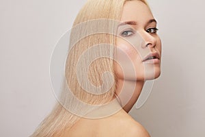 Beautiful woman with straight blond hair. Model with natural style make-up, clean skin. Shiny long health hairstyle