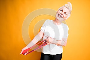 Beautiful woman stretching an elastic band for workouts laughing and looking at the camera