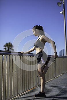 Beautiful woman stretching legs in Barcelona seafront beach & x28;SPAIN