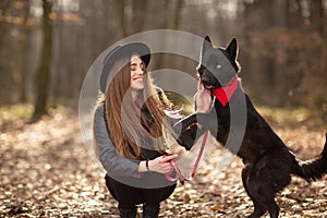 Beautiful woman stroking her dog outdoors. Pretty girl playing and having fun with her pet by name Brovko Vivchar