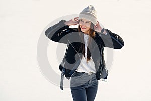 Beautiful woman at stylish jacket having fun, laugh on outdoor ice skating rink. Cheerful pretty young woman skate on