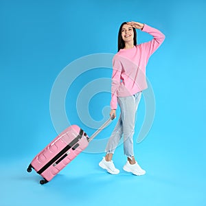Beautiful woman with suitcase for summer trip on background. Vacation travel
