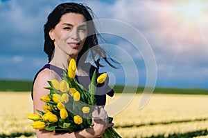 Beautiful Woman in summer dres standing in colorful tulip flower fields in Amsterdam region, Holland, Netherlands