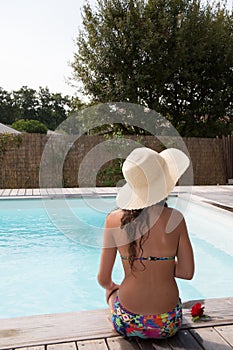 Beautiful woman sunbathing on the pool, back view