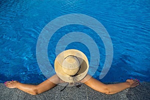 Beautiful woman sunbathing by the pool top view horizontal. Summer background.