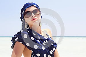 Beautiful woman in sunglasses on beach. arabian style