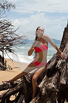 Beautiful woman in sunglasses and red bikini on beach. Fashion look. lady