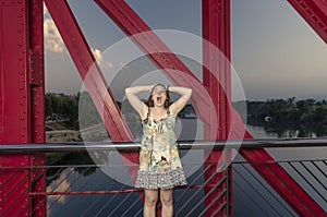 Beautiful woman surprised on a red bridge over Ebro, Spain.