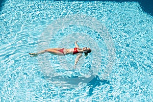 Beautiful woman swim at the blue pool enjoying summer holiday vacation and healthy lifestyle - people swimming in the water and