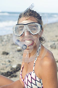 Beautiful woman with swimming goggles on the beach
