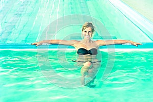 Beautiful woman in swimming pool looking at camera