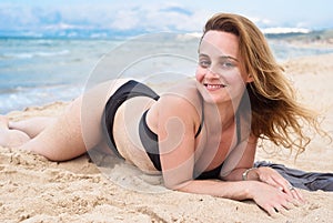 Beautiful woman in swimsuit relaxing on a beach