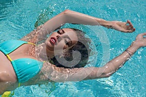 Beautiful woman in swimwear relaxing in swimming pool. Portrait of woman in bikini in water. Relaxed girl in swim pool