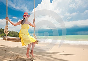 Beautiful woman swinging at tropical beach in Khao Lak region. Thailand, Asia