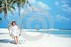 Beautiful woman swinging on a Tropical beach, Koh Phangan island. Thailand.