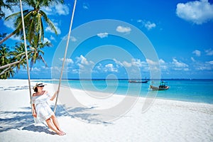 Beautiful woman swinging on a Tropical beach, Koh Phangan island. Thailand.