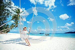 Beautiful woman swinging on a Tropical beach, Koh Phangan island. Thailand.