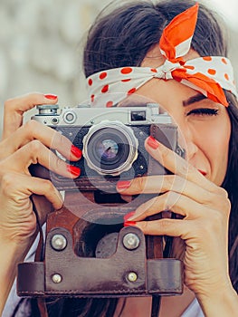 Beautiful woman taking photo with old fashioned film camera