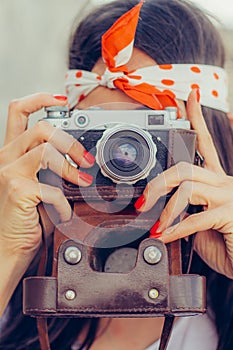 Beautiful woman taking photo with old fashioned film camera