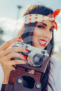 Beautiful woman taking photo with old fashioned film camera