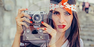 Beautiful woman taking photo with old fashioned film camera