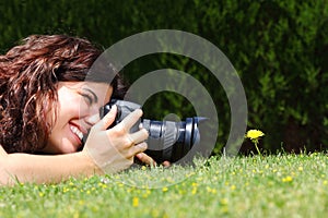 Beautiful woman taking a photography of a flower on the grass