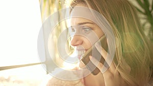 Beautiful woman talking phone. Portrait of talking woman smile in sun light
