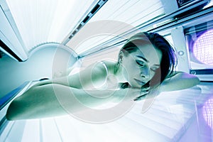 Beautiful woman tanning in solarium