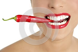 Beautiful woman teeth eating red pepper