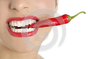 Beautiful woman teeth eating red pepper