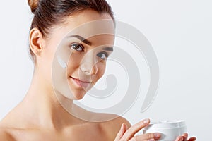 Beautiful woman tender jar of moisturizer cream. Close-up fresh young woman face.