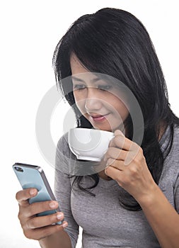 Beautiful woman texting on mobile phone and drinki