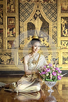 A beautiful woman in Thai national costume during the Ayuthaya period was sitting on a string of garlands. And smile beautifully