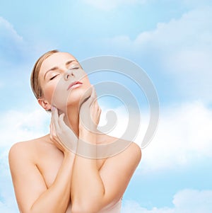 Beautiful woman touching her face with closed eyes