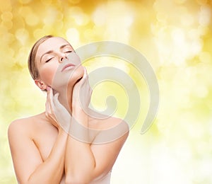 Beautiful woman touching her face with closed eyes