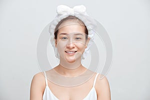 Beautiful woman with a towel on her head on a white background