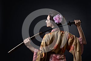 Beautiful woman in traditional Japanese kimono with katana