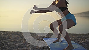 Beautiful woman trains on the beach. Sea, sunrise, beach, workout, slow motion