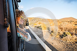 Beautiful woman travel on a car looking outside and enjoy the light of the golden sunset on her face. nice lifestyle and peaceful