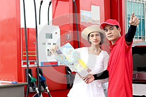Beautiful woman traveler holding touristic map while asking gas station attendant staff for finding right direction, cute female